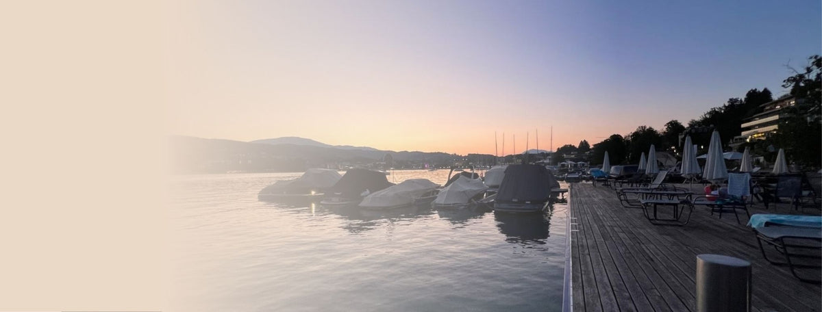 Wörthersee in der Abenddämmerung mit Bergen am Ufer